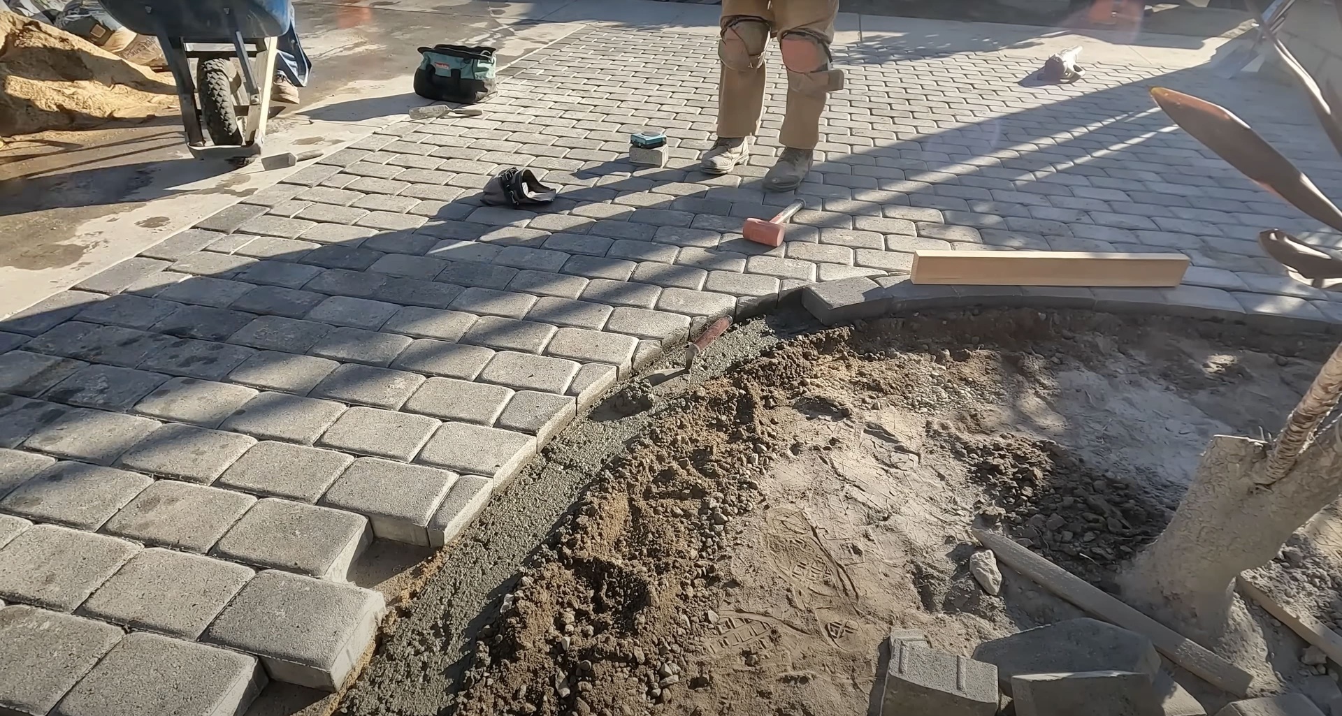 Concrete paver installation work in progress showing precision and attention to detail