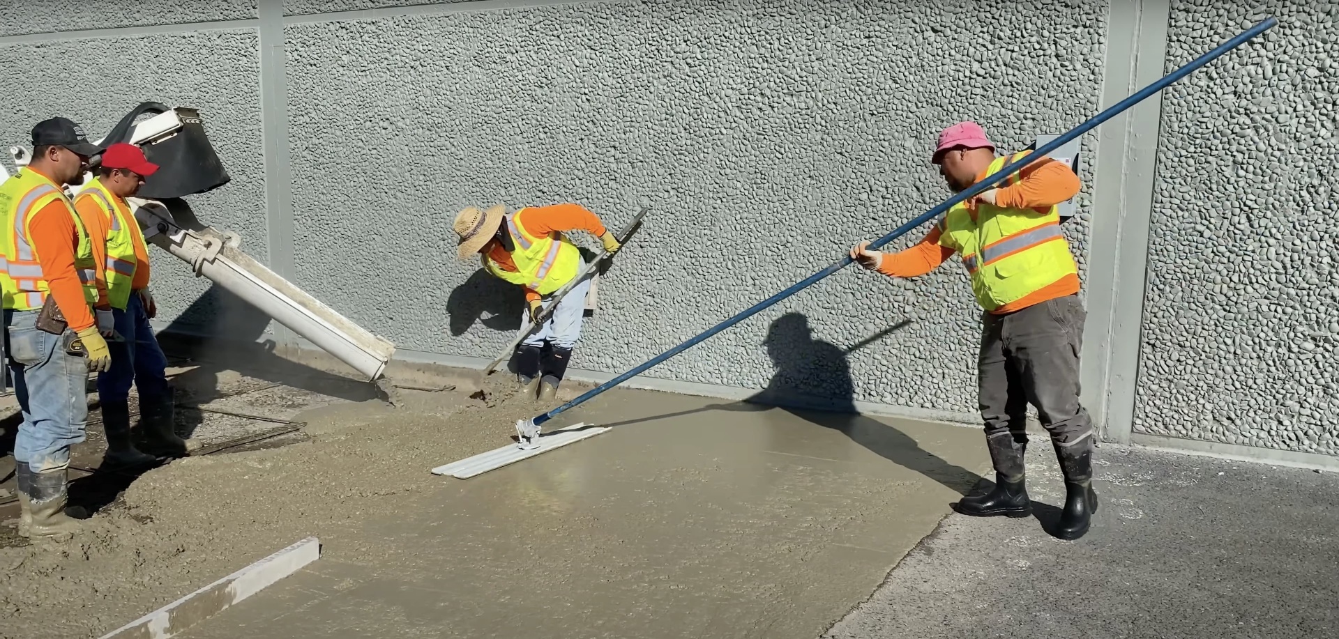 Professional concrete crew using specialized equipment for driveway installation